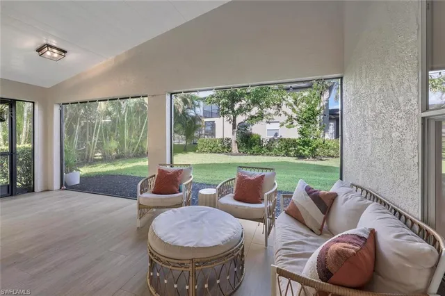 a living room with furniture and a floor to ceiling window