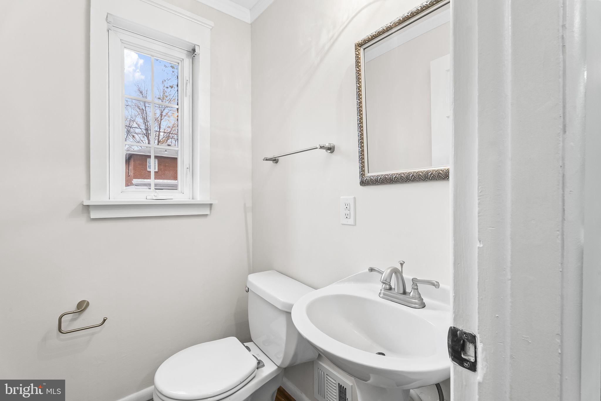 433 Earl Street Alexandria, VA 22314 - Photo 13 of 30 a bathroom with a toilet a sink and mirror