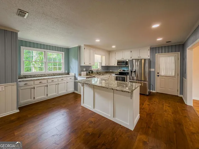 a view of a kitchen with a stove cabinets wooden floor and a kitchen