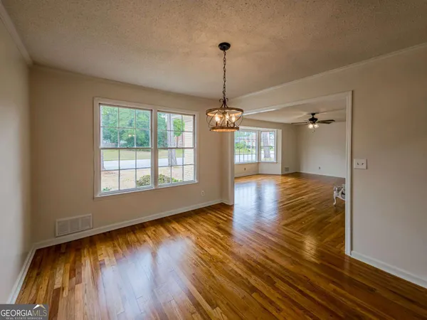 a view of empty room with wooden floor
