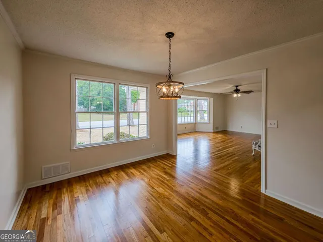 a view of empty room with wooden floor