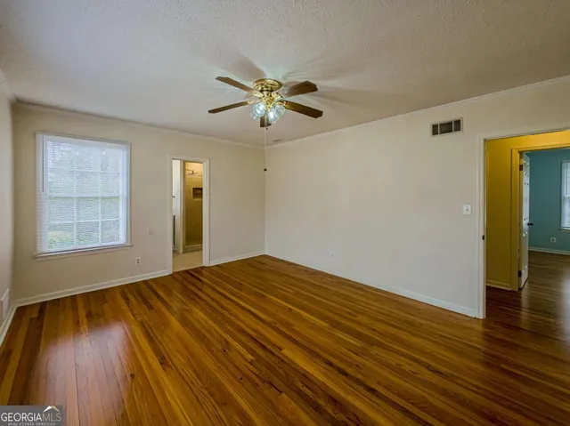 a view of an empty room with wooden floor