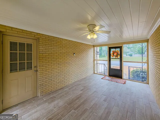a balcony with table and chairs and potted plants