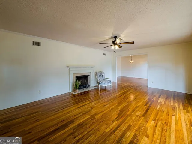 a view of a kitchen with kitchen island a counter top space appliances and a ceiling fan