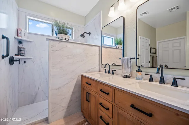 a bathroom with a double vanity sink a mirror and shower