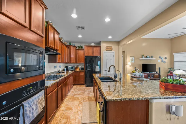 a kitchen with stainless steel appliances kitchen island granite countertop a sink and cabinets