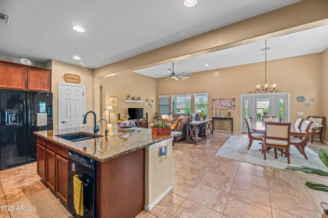 a kitchen with stainless steel appliances granite countertop a sink and a refrigerator