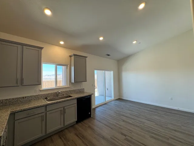 a large kitchen with stainless steel appliances granite countertop a sink and cabinets with wooden floor