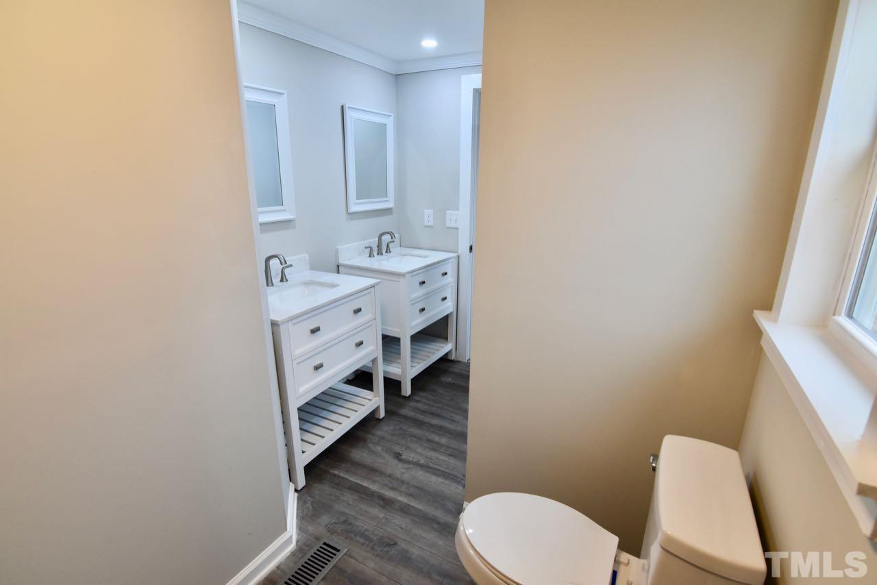 10110 Timothy Road Dunn, NC 28334 - Photo 27 of 41 a bathroom with a toilet a sink and mirror