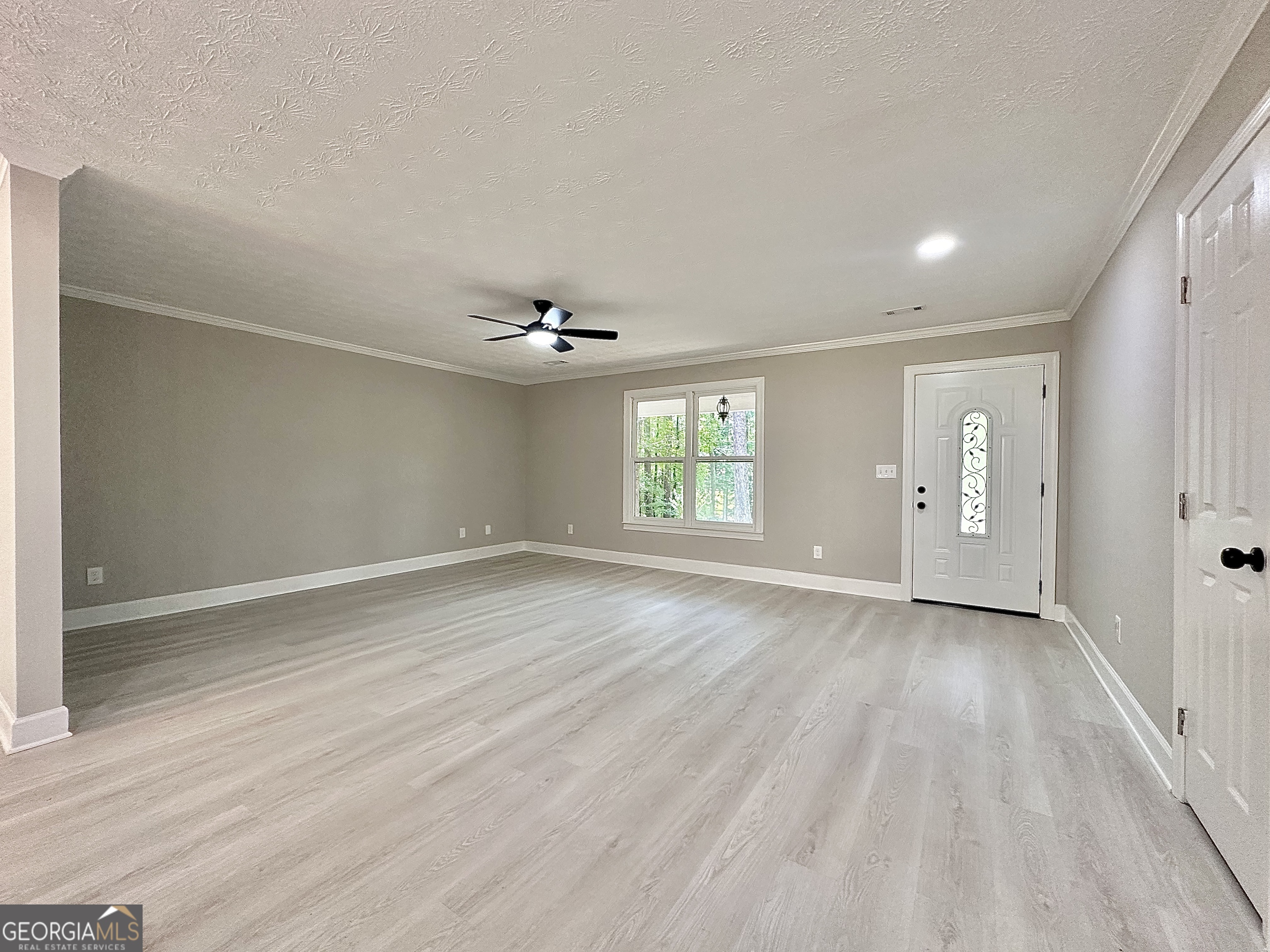 115 Creekside Lane Covington, GA 30016 - Photo 31 of 59 an empty room with wooden floor and windows