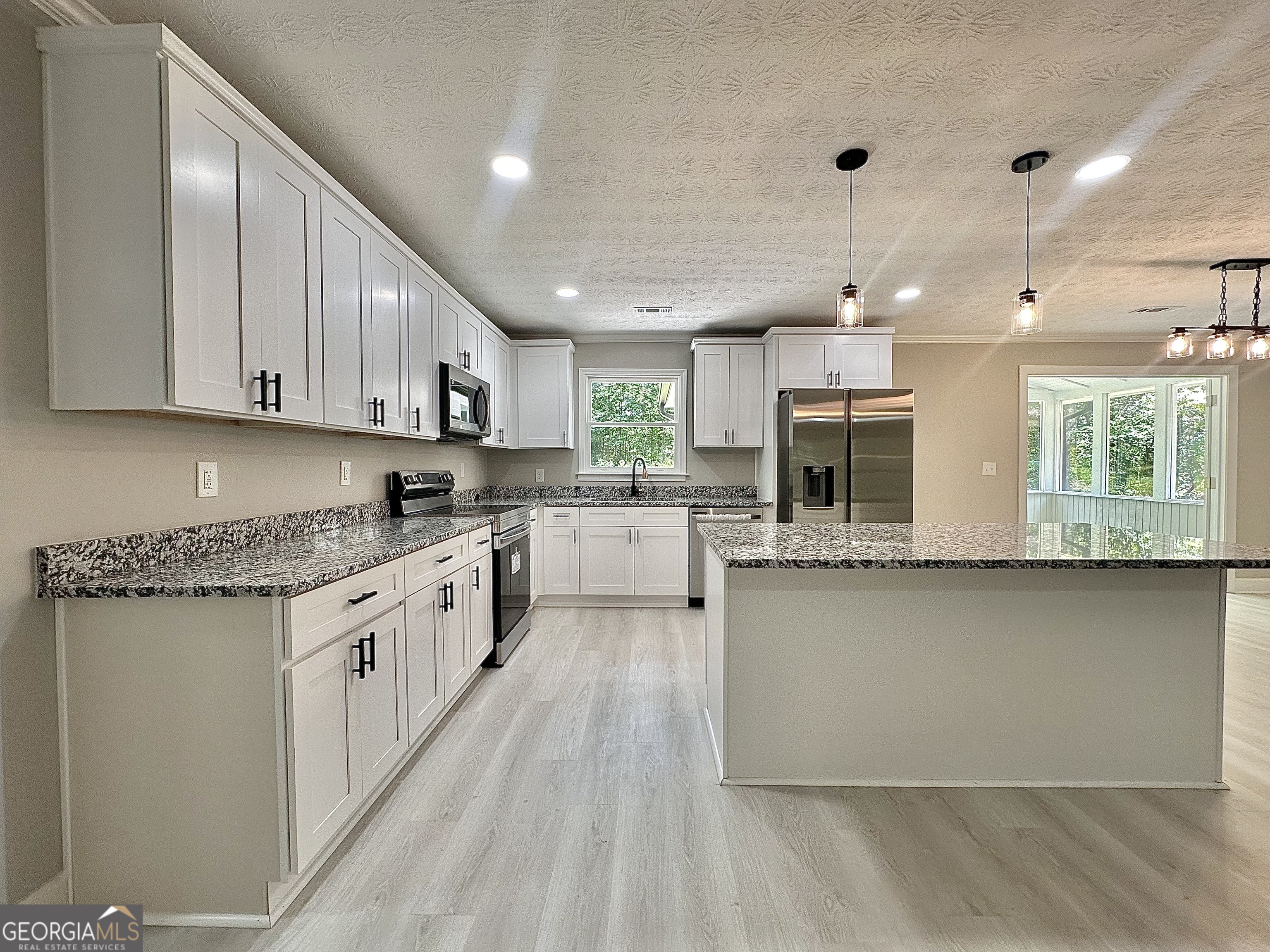 115 Creekside Lane Covington, GA 30016 - Photo 34 of 59 a large kitchen with stainless steel appliances granite countertop a lot of counter space and a sink