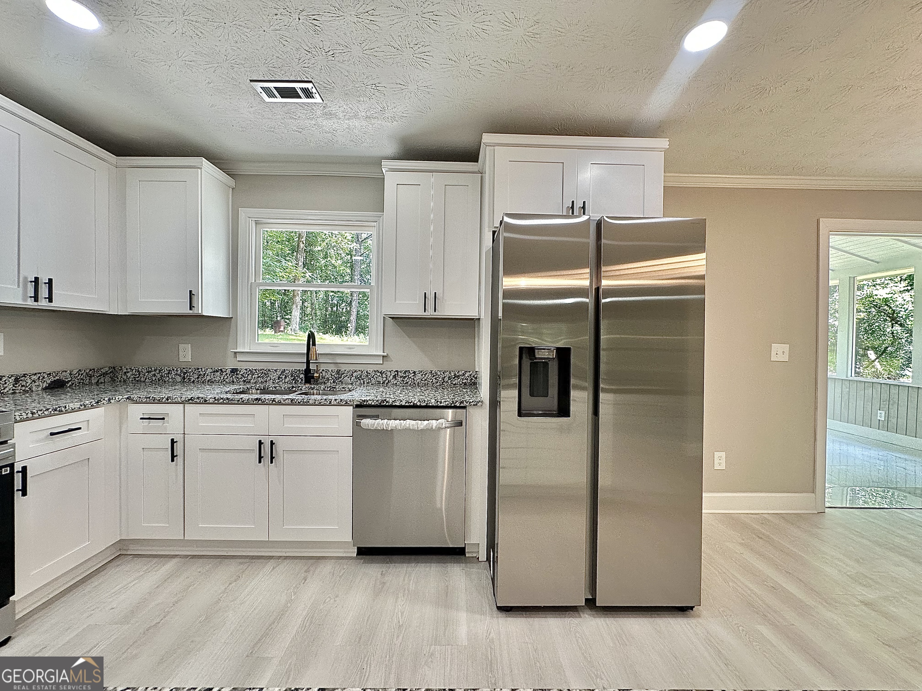 115 Creekside Lane Covington, GA 30016 - Photo 35 of 59 a kitchen with granite countertop cabinets stainless steel appliances and a window