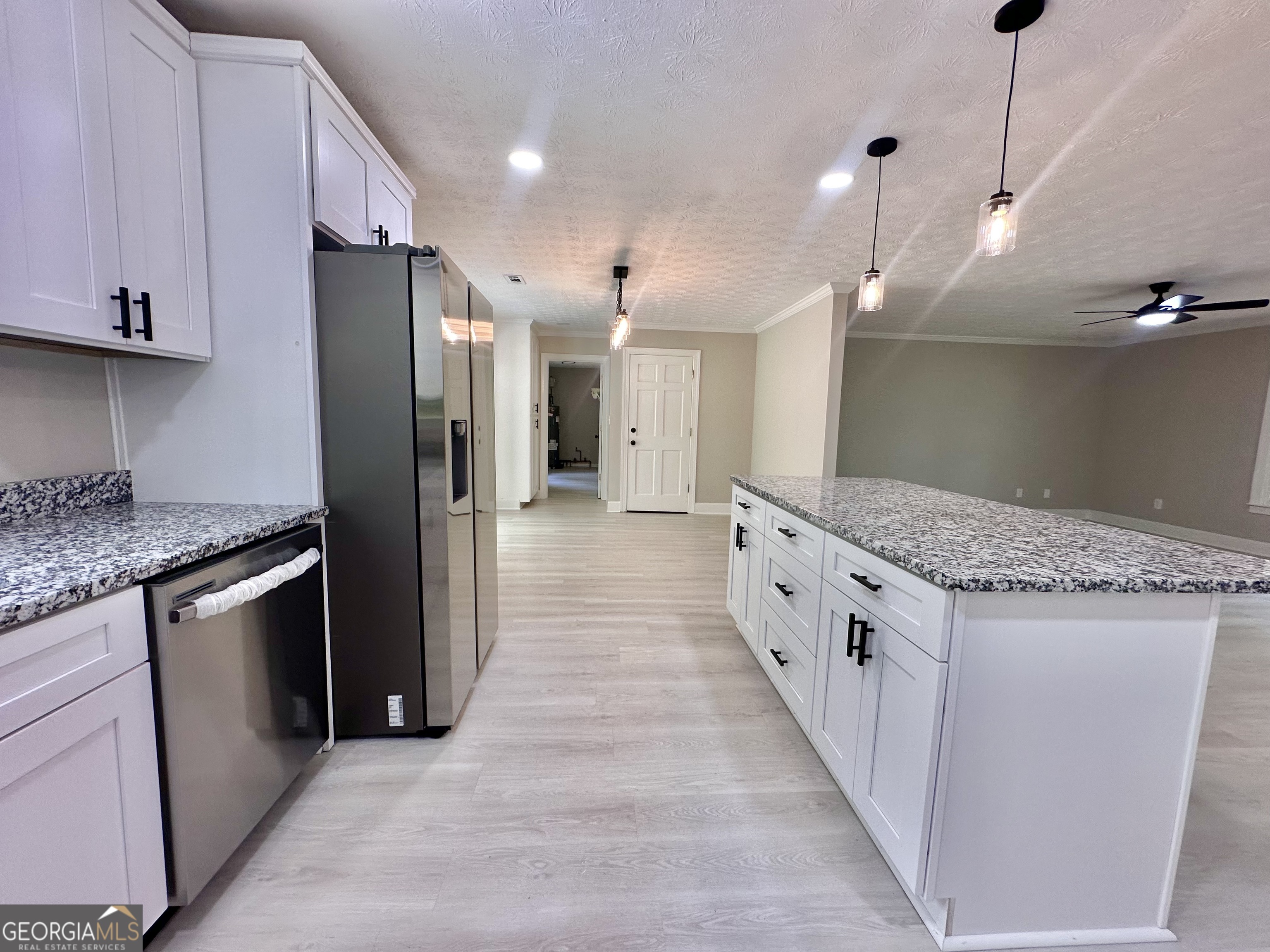 115 Creekside Lane Covington, GA 30016 - Photo 36 of 59 a large kitchen with stainless steel appliances kitchen island granite countertop a refrigerator and a sink