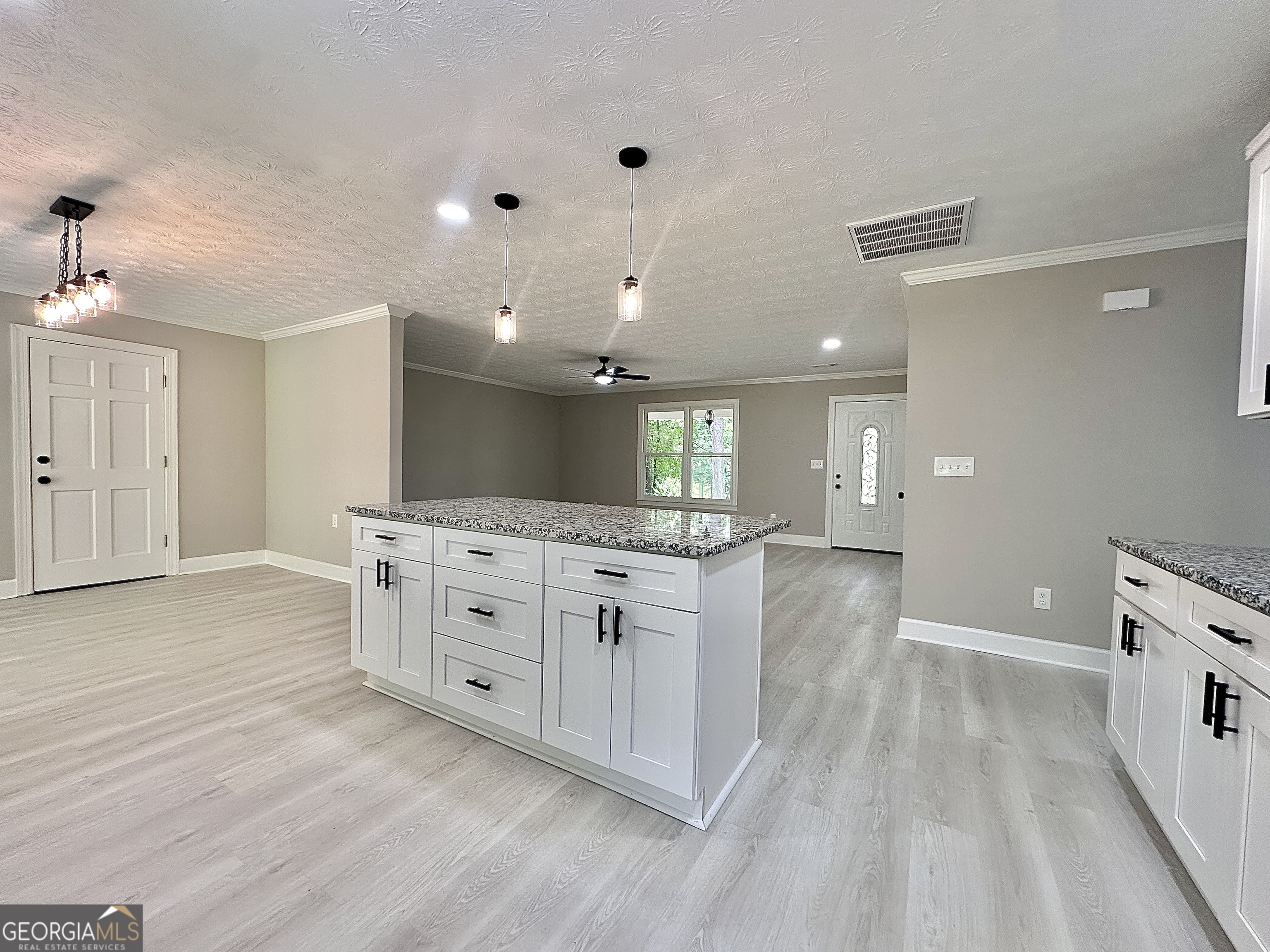 115 Creekside Lane Covington, GA 30016 - Photo 37 of 59 a large white kitchen with a large island oven a sink dishwasher and white cabinets with wooden floor