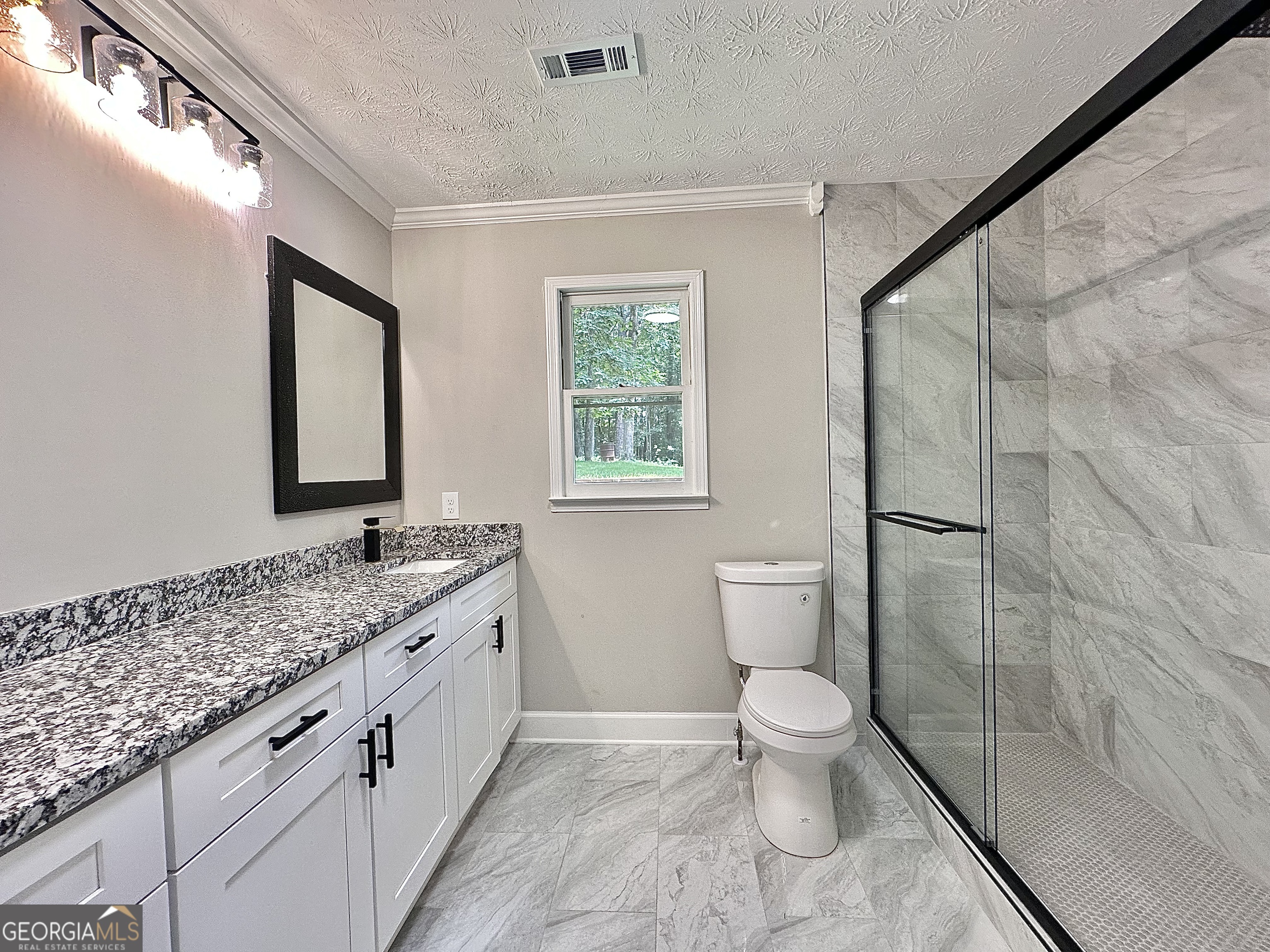 115 Creekside Lane Covington, GA 30016 - Photo 51 of 59 a spacious bathroom with a granite countertop sink toilet and shower