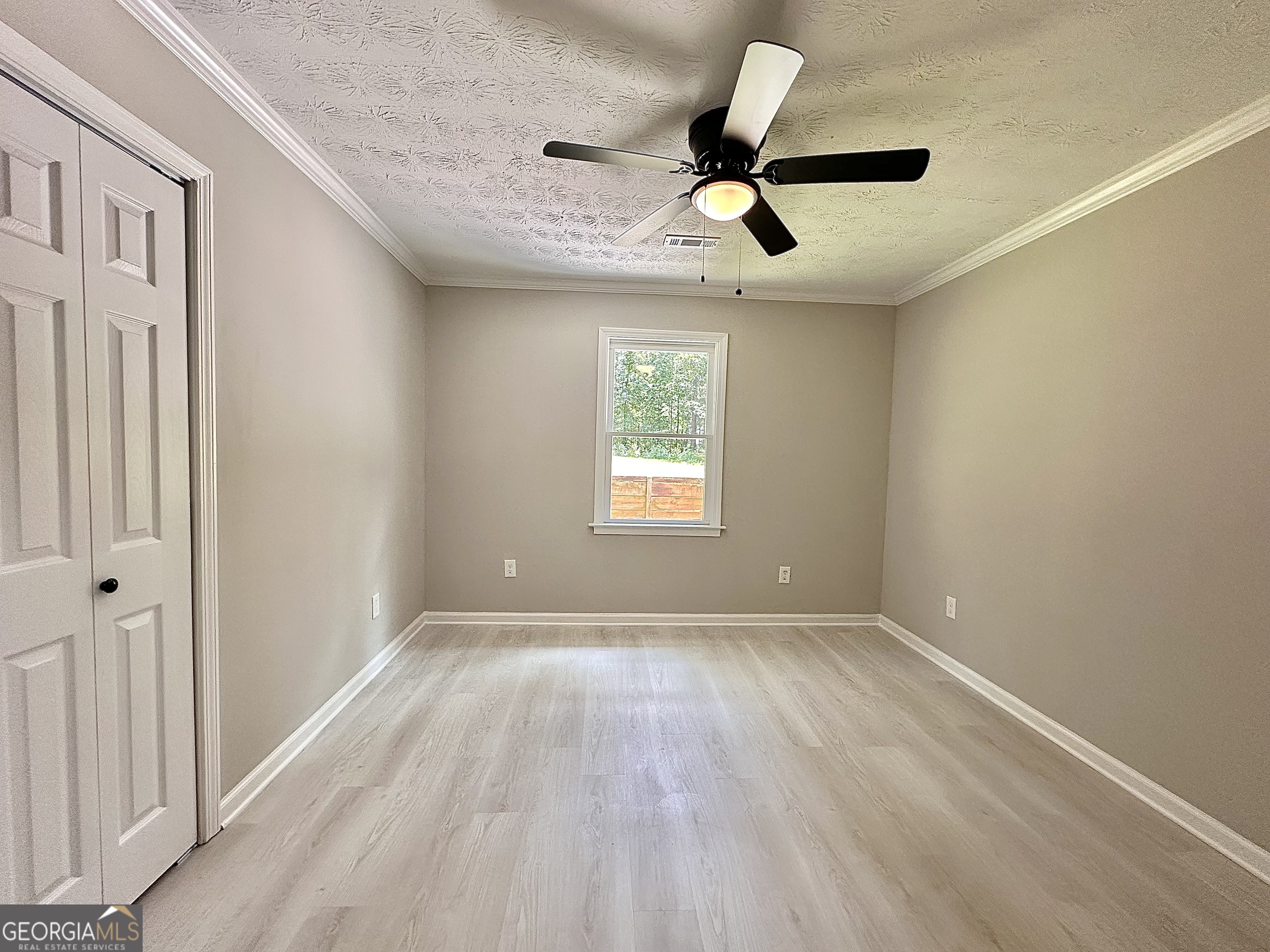 115 Creekside Lane Covington, GA 30016 - Photo 56 of 59 a view of a big room with wooden floor windows and ceiling fan
