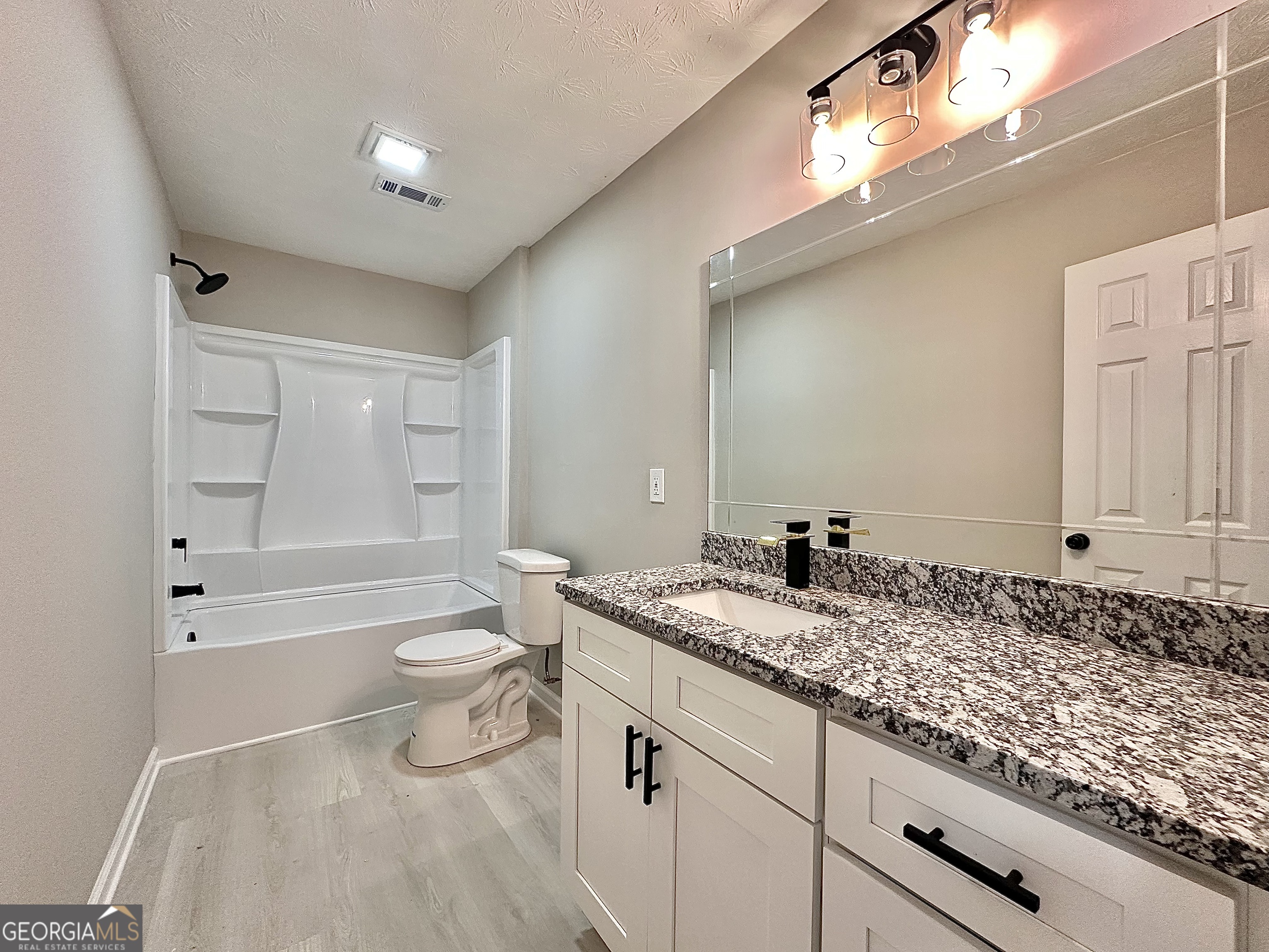 115 Creekside Lane Covington, GA 30016 - Photo 57 of 59 a bathroom with a granite countertop sink a toilet and bathtub