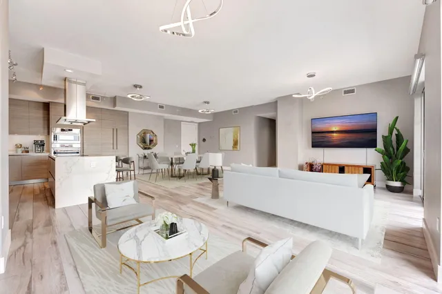 a view of a livingroom with wooden floor and furniture