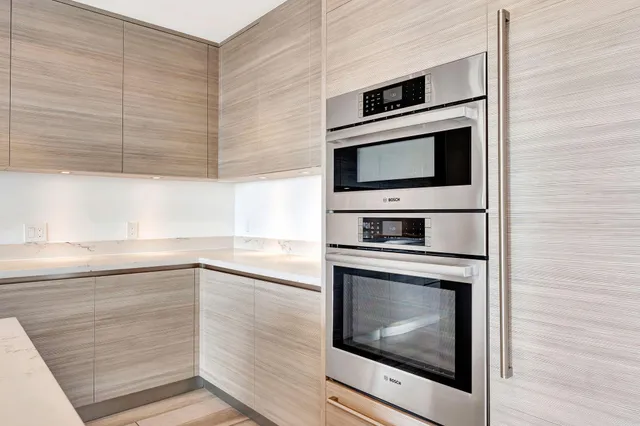 a view of a bedroom with wooden floor and a bathroom