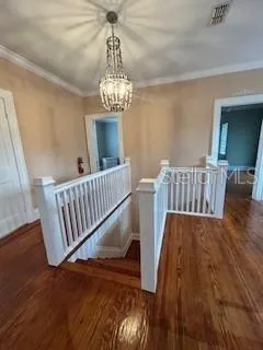 a view of a bedroom with wooden floor and windows
