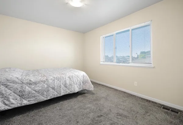 a bed sitting in a bedroom next to a window