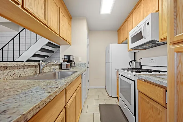 a kitchen with stainless steel appliances granite countertop a sink and a stove
