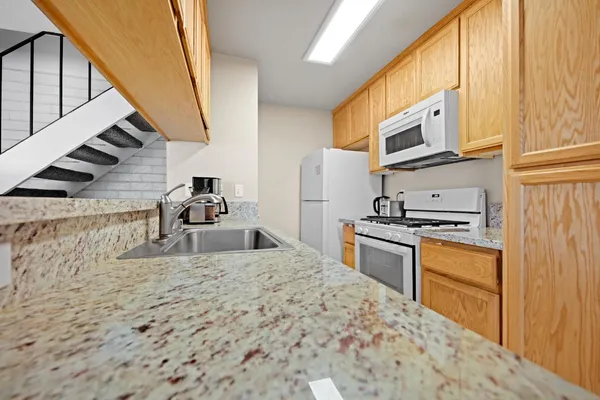 a kitchen with stainless steel appliances granite countertop a stove a sink and a refrigerator