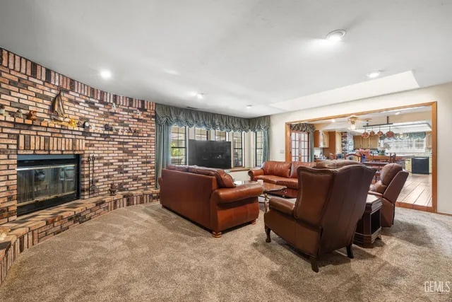 a living room with furniture a fireplace and a floor to ceiling window