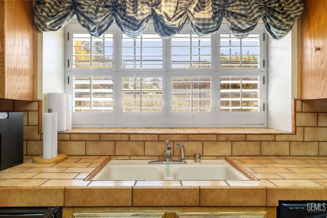 a large kitchen with kitchen island a stove a sink a counter top space and cabinets