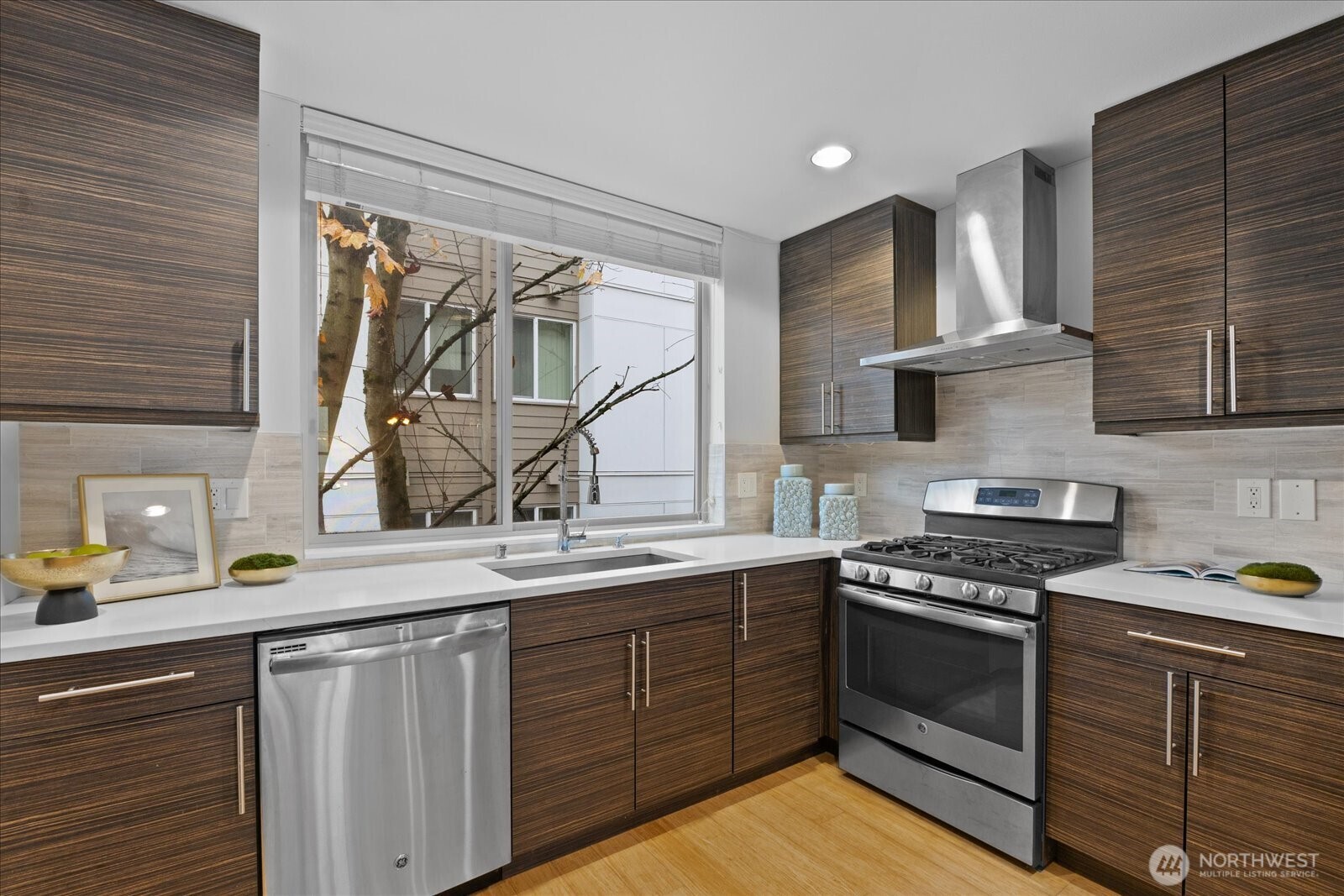 1525 Northwest 58th Street, Unit A Seattle, WA 98107 - Photo 7 of 24 a kitchen with a sink stainless steel appliances and cabinets