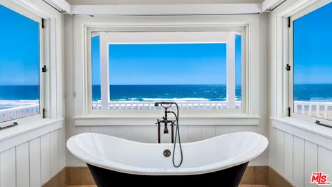 a bedroom with a bed and a large mirror on the wall