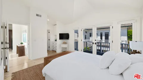 a bedroom with furniture and a large window