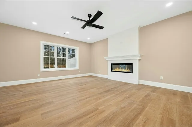 a view of an empty room with a window and fireplace
