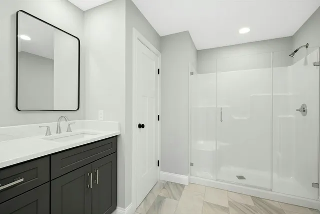 a bathroom with a shower sink and mirror