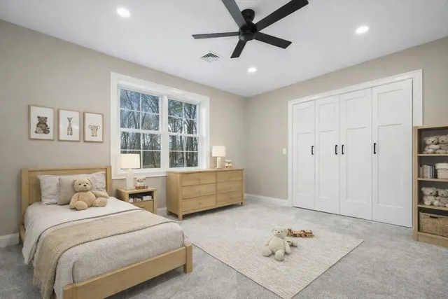 a bedroom with a bed a window and potted plant