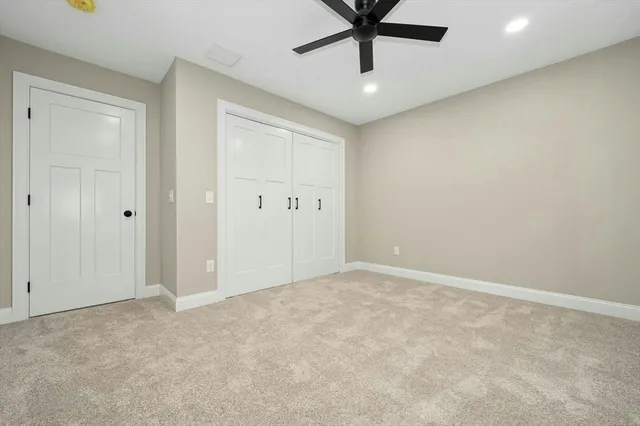 an empty room with a ceiling fan and window