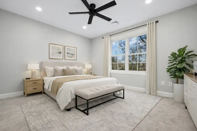 a spacious bedroom with a bed and a window