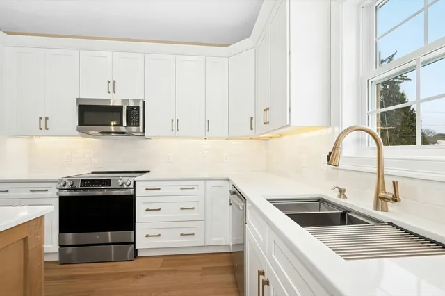 a kitchen with granite countertop a stove a sink and a microwave