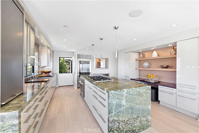 a dining hall with stainless steel appliances granite countertop a stove and a table chair