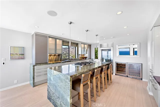 a kitchen with stainless steel appliances a stove a sink a oven a dining table and chairs