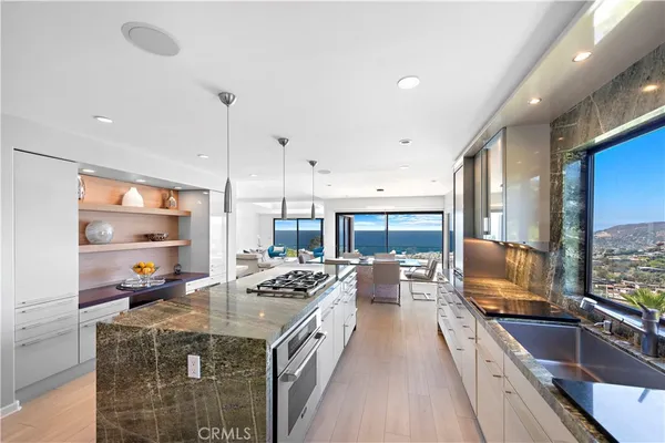 a kitchen with stainless steel appliances kitchen island granite countertop a sink stove and cabinets