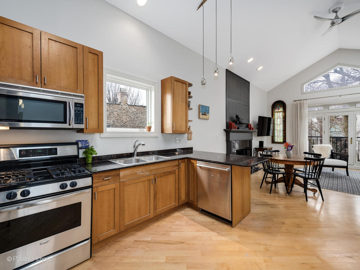 2039 West Rice Street, Unit 3 Chicago, IL 60622 - Photo 8 of 18 a kitchen with stainless steel appliances granite countertop a stove top oven a sink dishwasher a dining table and chairs with wooden floor