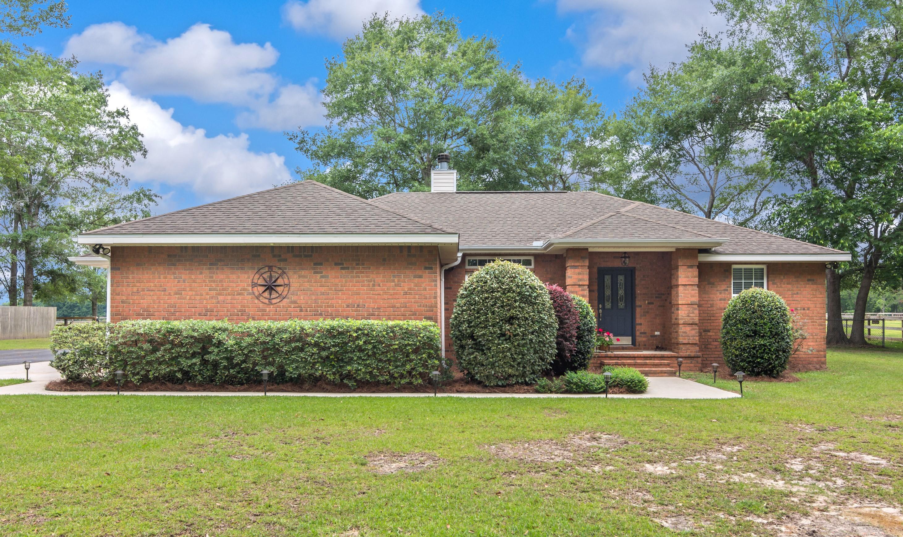 5780 Griffith Mill Road Baker, FL 32531 - Photo 4 of 50 a front view of a house with a garden and yard