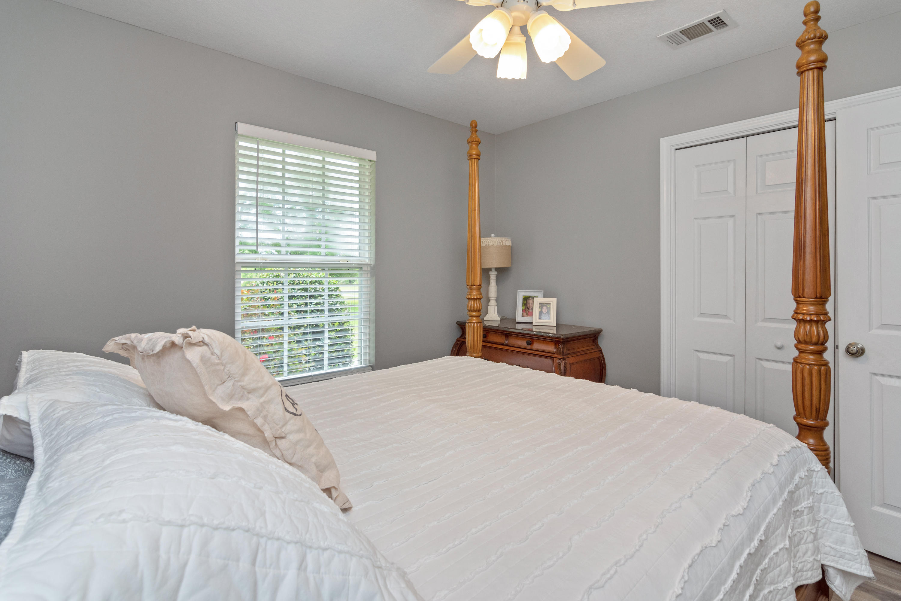 5780 Griffith Mill Road Baker, FL 32531 - Photo 31 of 50 a bedroom with a large bed and a chandelier