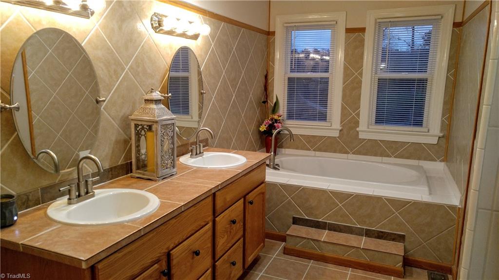 6251 Phillippi Road Julian, NC 27283 - Photo 15 of 30 Master bathroom with double sinks, stall shower, large soaking tub, and closet! Newly tiled stall shower!