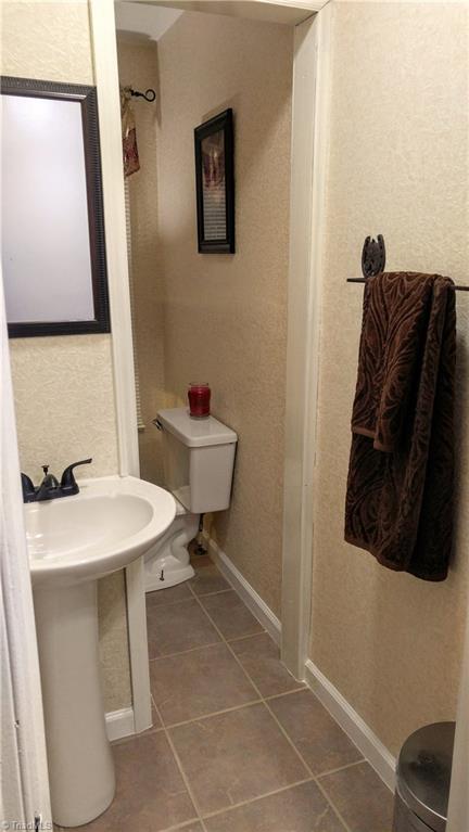 6251 Phillippi Road Julian, NC 27283 - Photo 20 of 30 Downstairs 1/2 bath with new tile and pedestal sink!