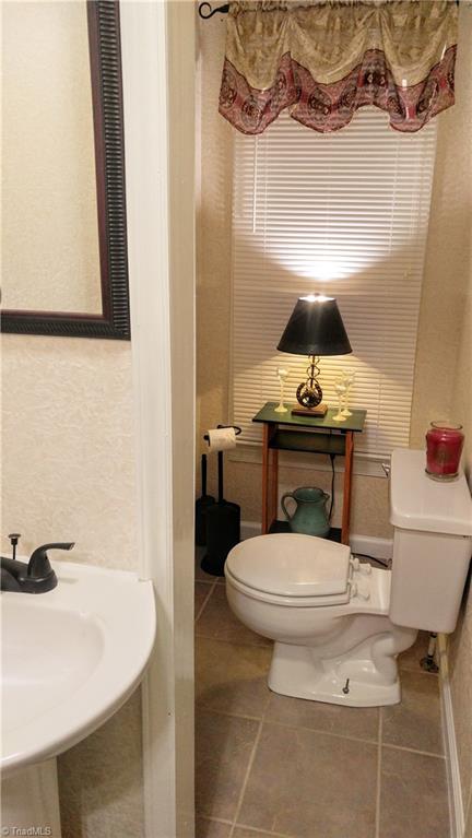 6251 Phillippi Road Julian, NC 27283 - Photo 21 of 30 Downstairs 1/2 bath with new tile and pedestal sink!