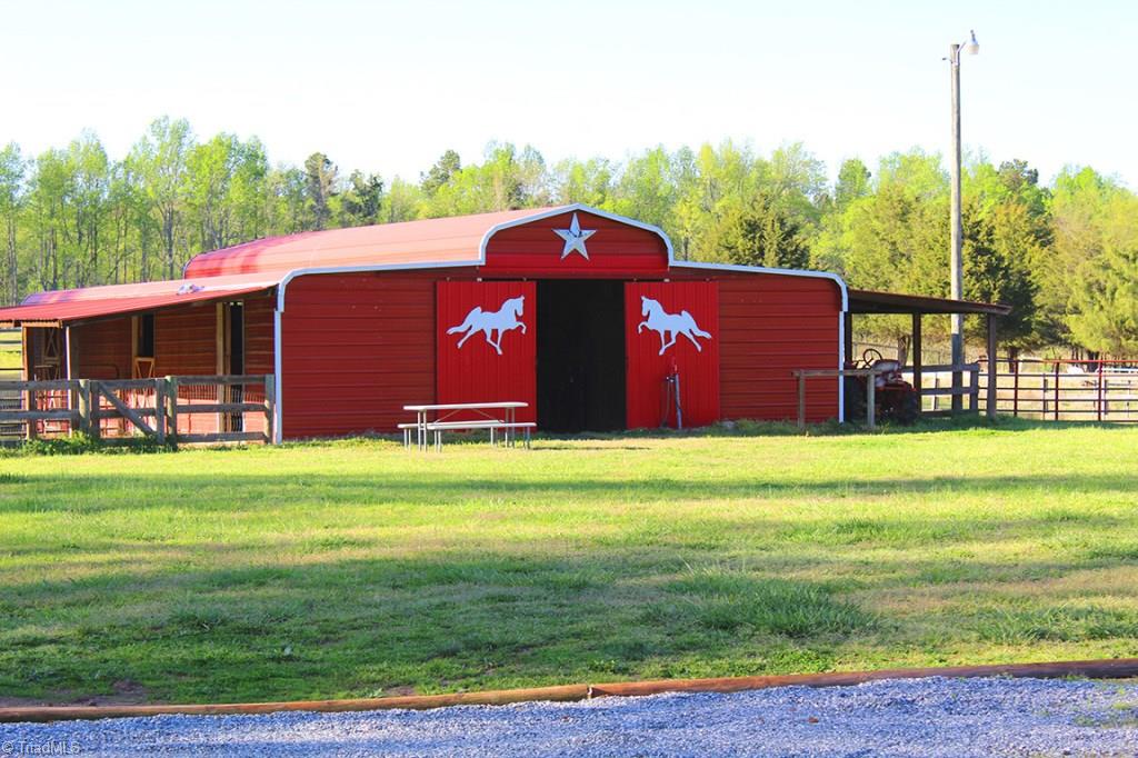 6251 Phillippi Road Julian, NC 27283 - Photo 27 of 30 6 stall barn with power, water, and tack room! Lean-to's off both sides of the metal barn and a center ally way that make this a very roomy barn!