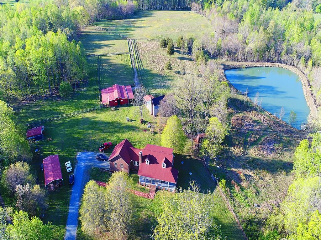 6251 Phillippi Road Julian, NC 27283 - Photo 29 of 30 Aerial view with home and garage, metal carport, 6 stall barn, hay barn, pond and lots of pasture!