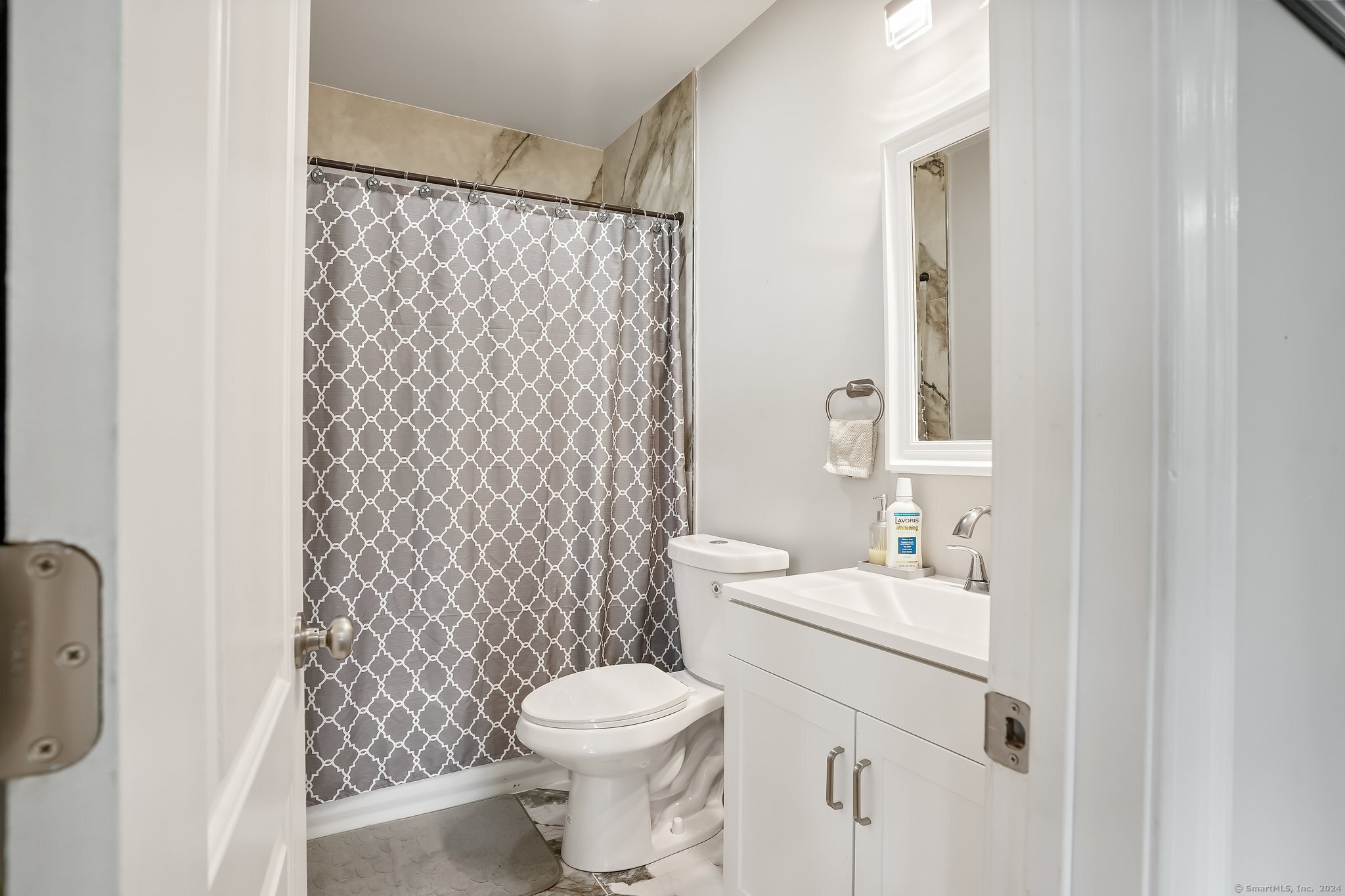 75 Hemlock Street Bridgeport, CT 06605 - Photo 12 of 24 a bathroom with a sink a toilet and shower curtain